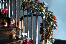 56 a fantastic Christmas decoration of faux leaves and flowers with colorful baubles and matching arrangements right on the stairs for those who love color