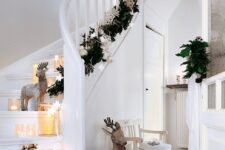 65 Scandinavian stairs decor with candle lanterns and candleholders, deer, stars and an evergreen garland with silver and white ornaments