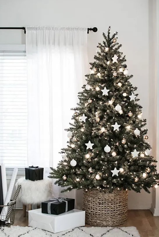 a Chrismas tree with white and metlalic ornaments and lights placed into a basket is a chic and cool idea for a Scandinavian space