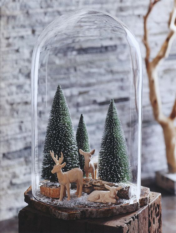 a Christmas terrarium with deer figurines, bottle brush Christmas trees and some logs is a lovely idea
