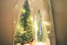a Christmas terrarium with faux snow, a deer, lights, bottle brush trees is a lovely idea for the holidays