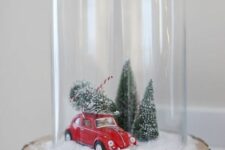 a Christmas terrarium with faux snow, a red car, some Christmas trees on a wood slice is a lovely idea