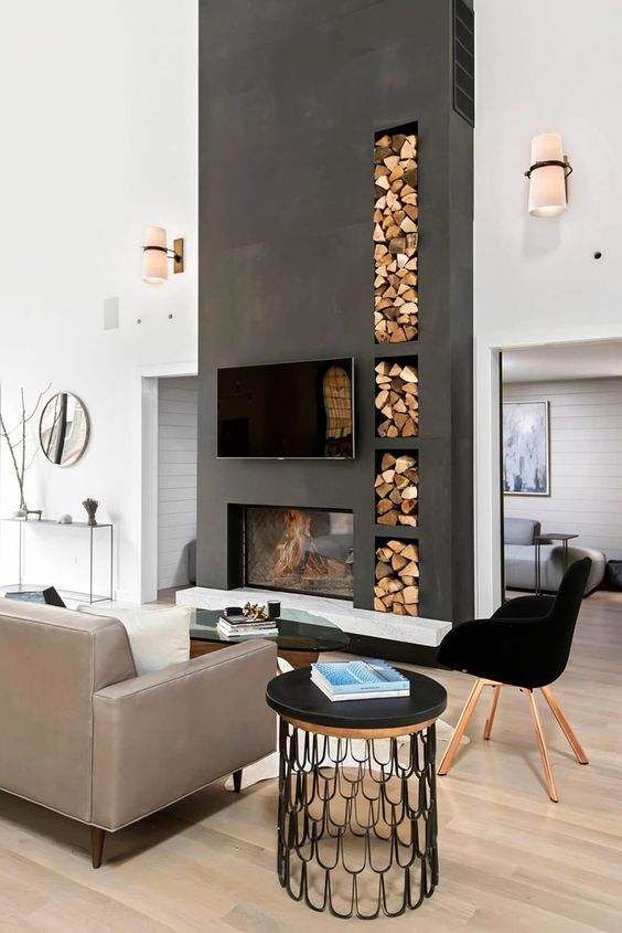 a Scandinavian living room is separated with a statement concrete double-sided fireplace into two parts