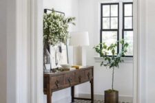 a beautiful eclectic entryway with windows including a transom one is light-filled and highlit with black framing and tiles