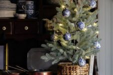 a beautiful tabletop Christmas tree with lights and chinoiserie ornaments placed into a basket is a lovely idea