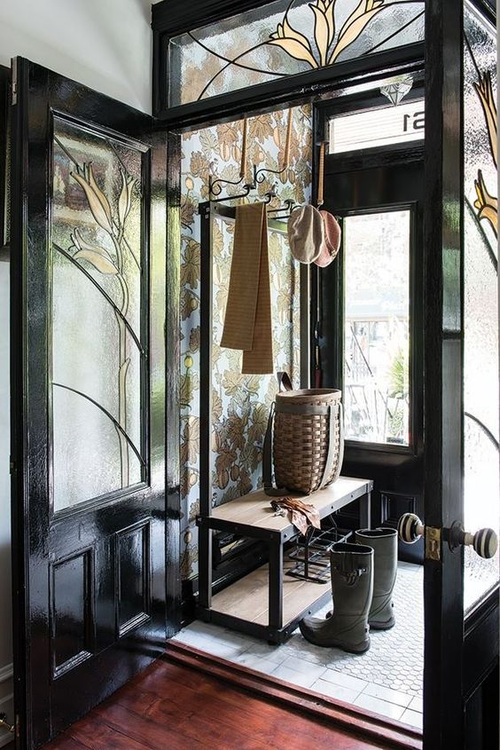 a beautiful vintage entryway done with black glass doors and transom windows is a fantastic space with plenty of natural light