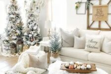 a beautiful winter wonderland Christmas space with trees with metallic ornaments, neutral pillows, chunky blankets, evergreens and ornaments