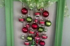 a bold green frame Christmas wreath of red and green ornaments and a green polka dot bow on top is a bold and cool idea