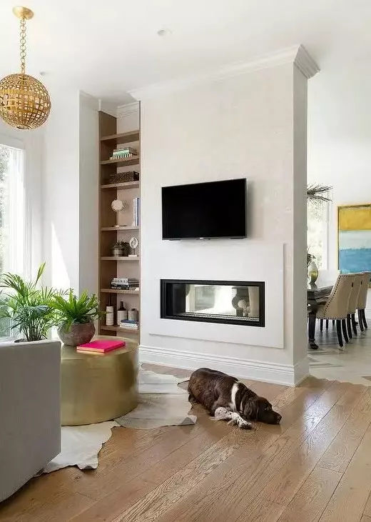 a built-in double-sided fireplace gives interest and a cozy feel to both the living room and the dining zone