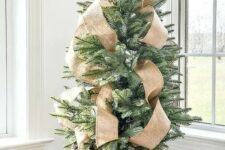 a chic and simple tabletop Christmas tree in a basket with burlap ribbons is a lovely idea with a slight and elegant rustic feel