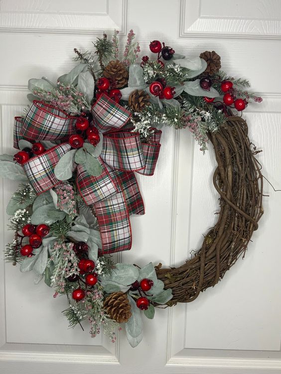 a classic rustic Christmas wreath with greenery, berries, pinecones, twigs and a plaid bow is a stylish and cool decor idea