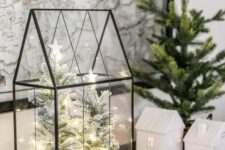 a classy modern Christmas terrarium with flocked mini trees inside and some lights is a very stylish and out of the box idea