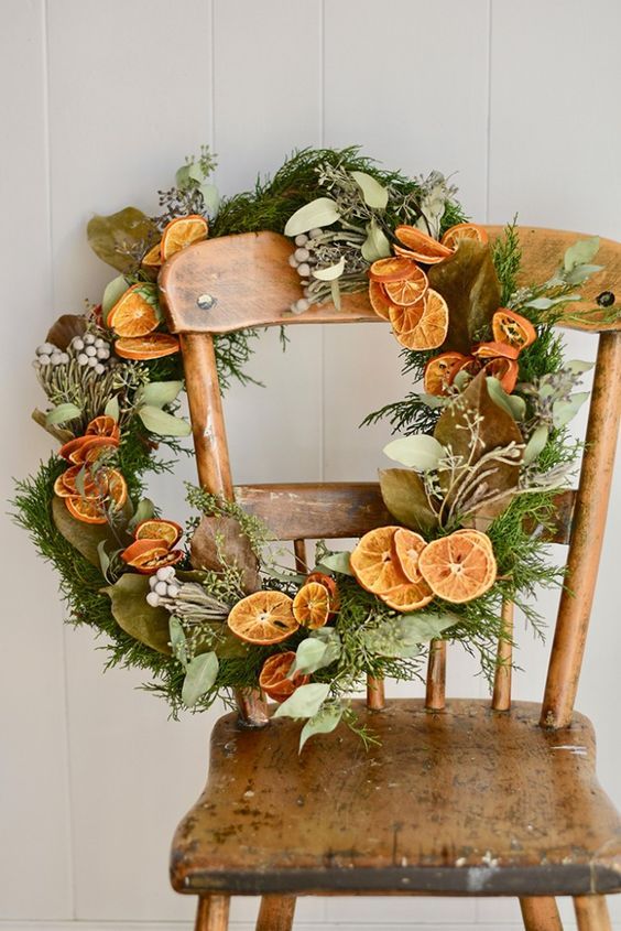 a cool modern rustic Christmas wreath with greenery, berries, citrus slices and foliage is a bold and cool decoration