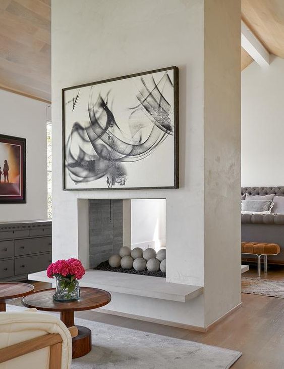 a double sided fireplace with concrete balls inside will easily become a decorative element for both spaces