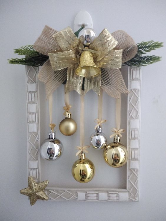 a frame Christmas wreath with a gold star, evergreens, silver and gold ornaments, burlap and a ribbon bow plus a bell
