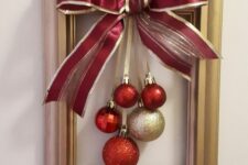 a frame Christmas wreath with red and gold rnaments and an oversized matching bow is a simple craft that looks cool