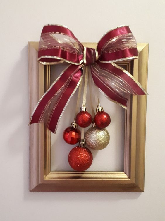 a frame Christmas wreath with red and gold rnaments and an oversized matching bow is a simple craft that looks cool