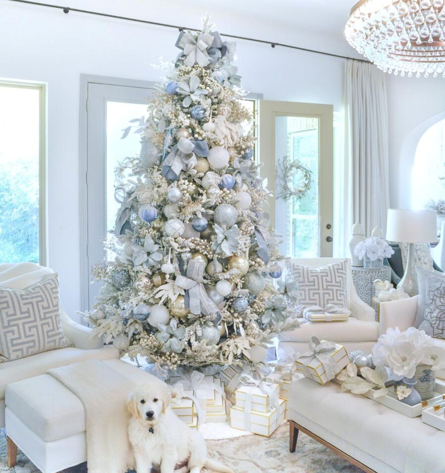 a glam Christmas tree decorated with white, silver, blue and pastel blue ornaments, ribbons and fabric poinsettias