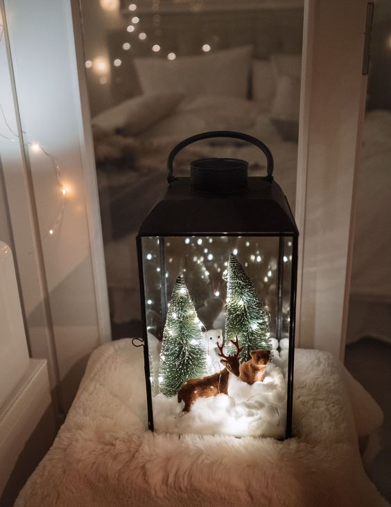 a lantern Christmas terrarium with faux snow, a deer and a bear, Christmas trees and lights is an awesome idea