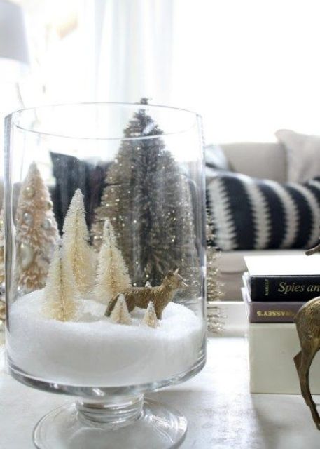 a large glass with faux snow, bottle brush Christmas trees and a fox is a simple and lovely idea for the holidays