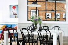 a large window with black frames that separates the dining room and kitchen and gives more light to both zones