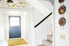 a light-filled entryway with transom windows done with colorful mosaics is a beautiful and chic space with a touch of color
