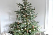 a lovely Christmas tree decorated with silver and gold ornaments, lights and natural pinecones is amazing