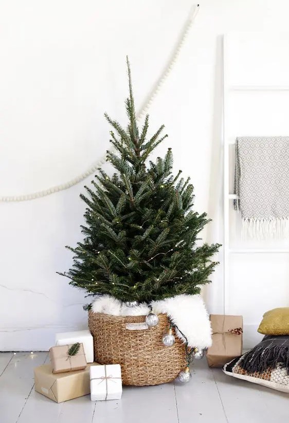 a minimalist Christmas tree with lights placed in a basket and covered with faux fur is an ultimate idea for any contemporary space