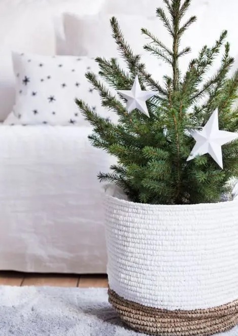 a modern Christmas tree in a tall woven basket, with oversized white stars is a gorgeous idea for your neutral space