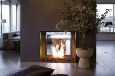 a modern double-sided fireplace done of grey concrete looks really spectacular and very chic