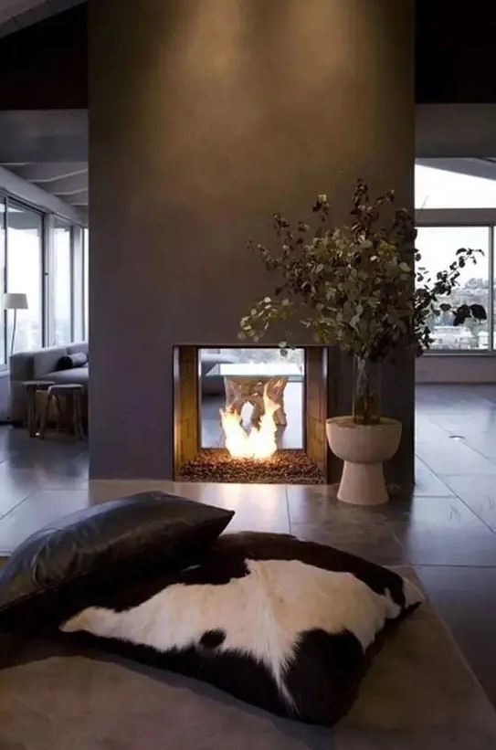 a modern double sided fireplace done of grey concrete looks really spectacular and very chic