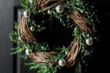 a modern rustic Christmas wreath with evergreens and silver ornaments is a gorgeous decoration to rock