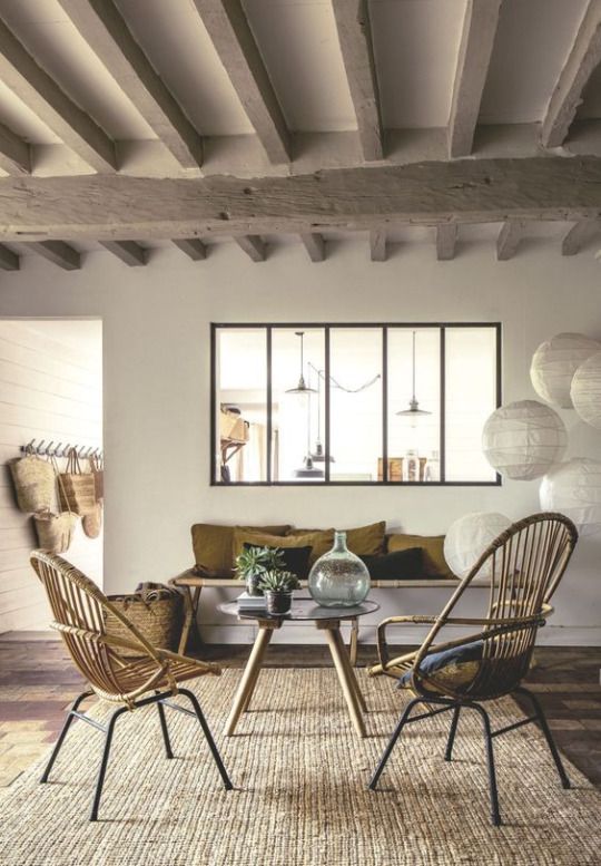 a modern rustic interior with an interior window that connects the living room and the kitchen is a welcoming space