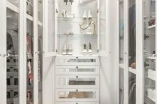 a narrow walk-in closet with glass doors, with open cabinets and shelves, with mirror drawers is a glam and refined idea