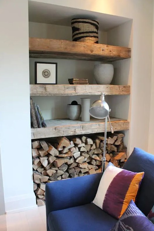 a niche styled with wooden shelves, for storing firewood, photos, baskets and planters