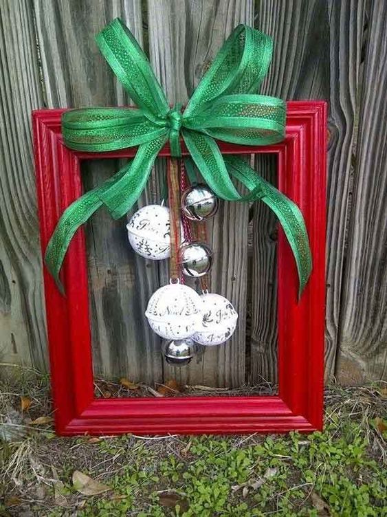 a red frame Christmas wreath with silver and white bells and a green bow is a lovely traditional decoration for the holidays