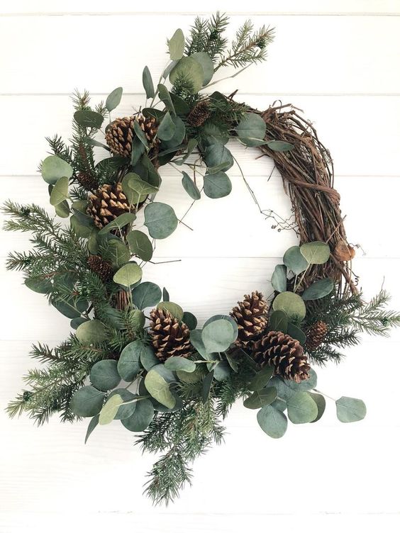 a rustic Christmas wreath with eucalyptus, evergreens and pinecones is a lovely and cozy decor idea to rock