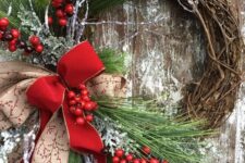 a rustic Christmas wreath with evergreens, berries, a couple of bows is a cozy and bold decoration for outdoors