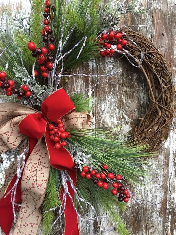 a rustic Christmas wreath with evergreens, berries, a couple of bows is a cozy and bold decoration for outdoors