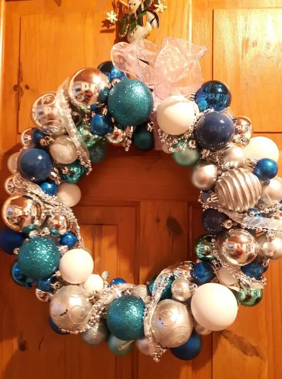 a shiny Christmas wreath of tiffany blue, navy, white and silver ornaments and ribbons is a pretty decoration to rock