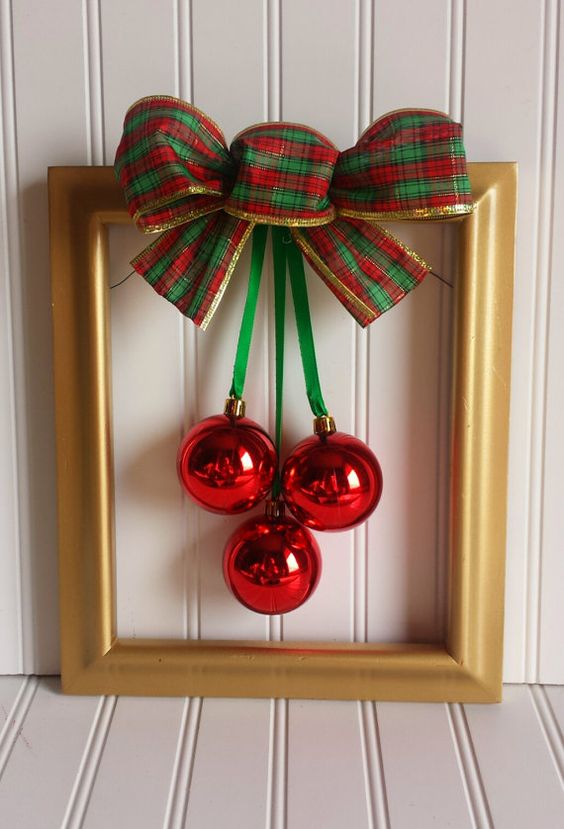 a simple and classy Christmas wreath of a gold frame, red ornaments and a green, red and gold bow on top can be easily DIYed