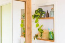 a small yet cool niche with light-stained shelves, a potted plant and some supplies is a lovely idea for a boho or mid-century modern space