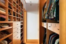 a stained narrow walk-in closet with lots of shelves, drawers and even steps to reach all the necessary things