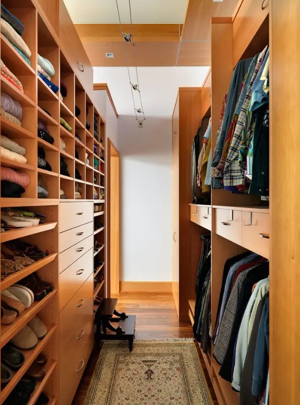 a stained narrow walk-in closet with lots of shelves, drawers and even steps to reach all the necessary things