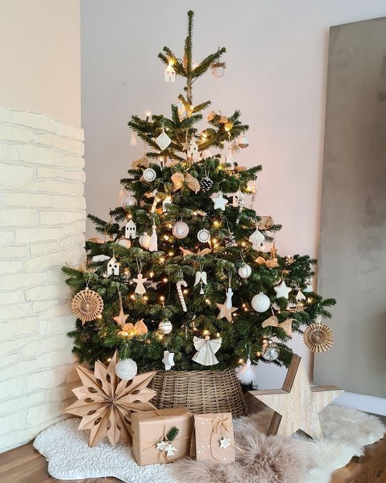 a stylish Christmas tree with a rustic feel, white and silver ornaments, lights, pinecones placed into a basket