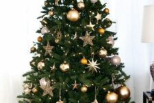 a stylish modern Christmas tree decorated with lights, silver, copper and gold ornaments, stars and snowflakes is awesome