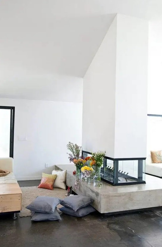 a stylish white double-sided fireplace with a glass part and a concrete one is a chic idea for a contemporary home