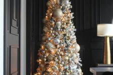 a super glam Christmas tree with silve rand gold plus white ornaments fully covering the tree and some twigs on top