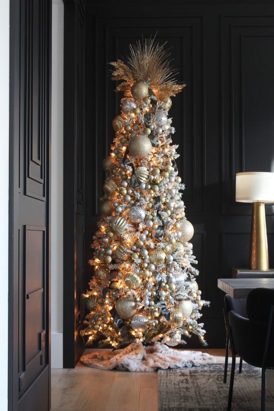a super glam Christmas tree with silve rand gold plus white ornaments fully covering the tree and some twigs on top