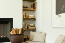a tall and narrow niche with dark-stained shelves and books on them is a cozy addition to the fireplace nook